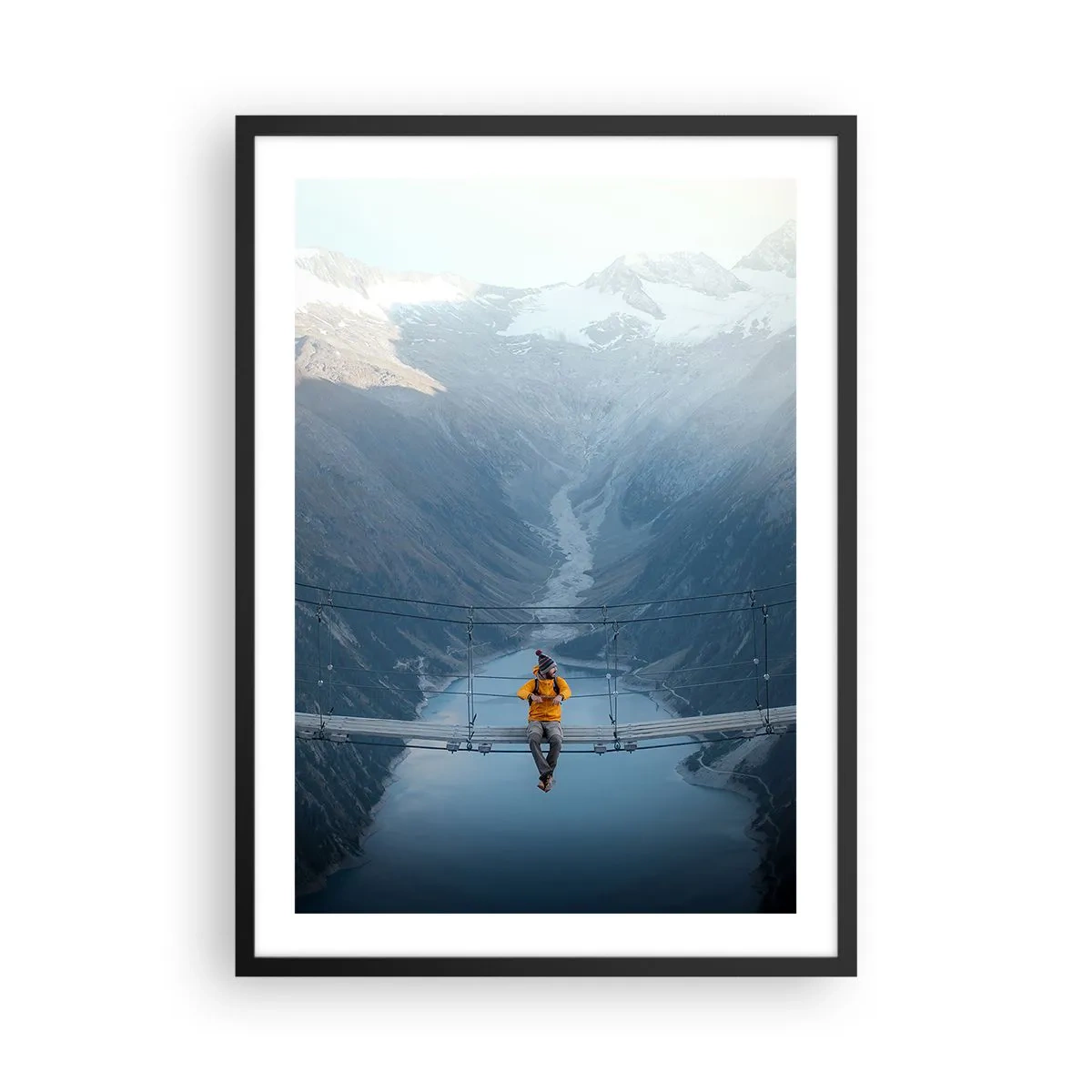 Poster in black frame - A person in a yellow jacket sitting on a suspension bridge over a valley - 50x70cm - Suspended in Delight - Modern wall decoration for the living room and bedroom ARTTOR