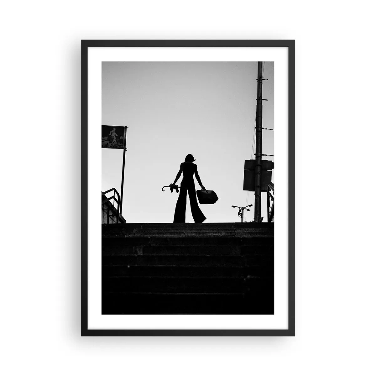 Poster in black frame - Silhouette of a woman with a suitcase against the backdrop of the setting sun - 50x70cm - City Wander - Modern wall decoration for the living room and bedroom ARTTOR