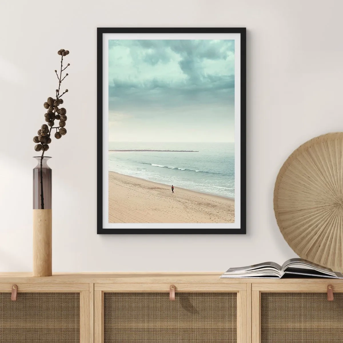 Poster in black frame - A lone figure walks along the seashore under an overcast sky. - 50x70cm - In Search of Quiet - Modern wall decoration for the living room and bedroom ARTTOR