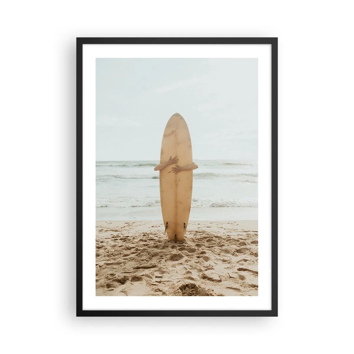 Poster in black frame - person holding a surfboard on a beach, overlooking the sea. - 50x70cm - From Love for the Waves - Modern wall decoration for the living room and bedroom ARTTOR