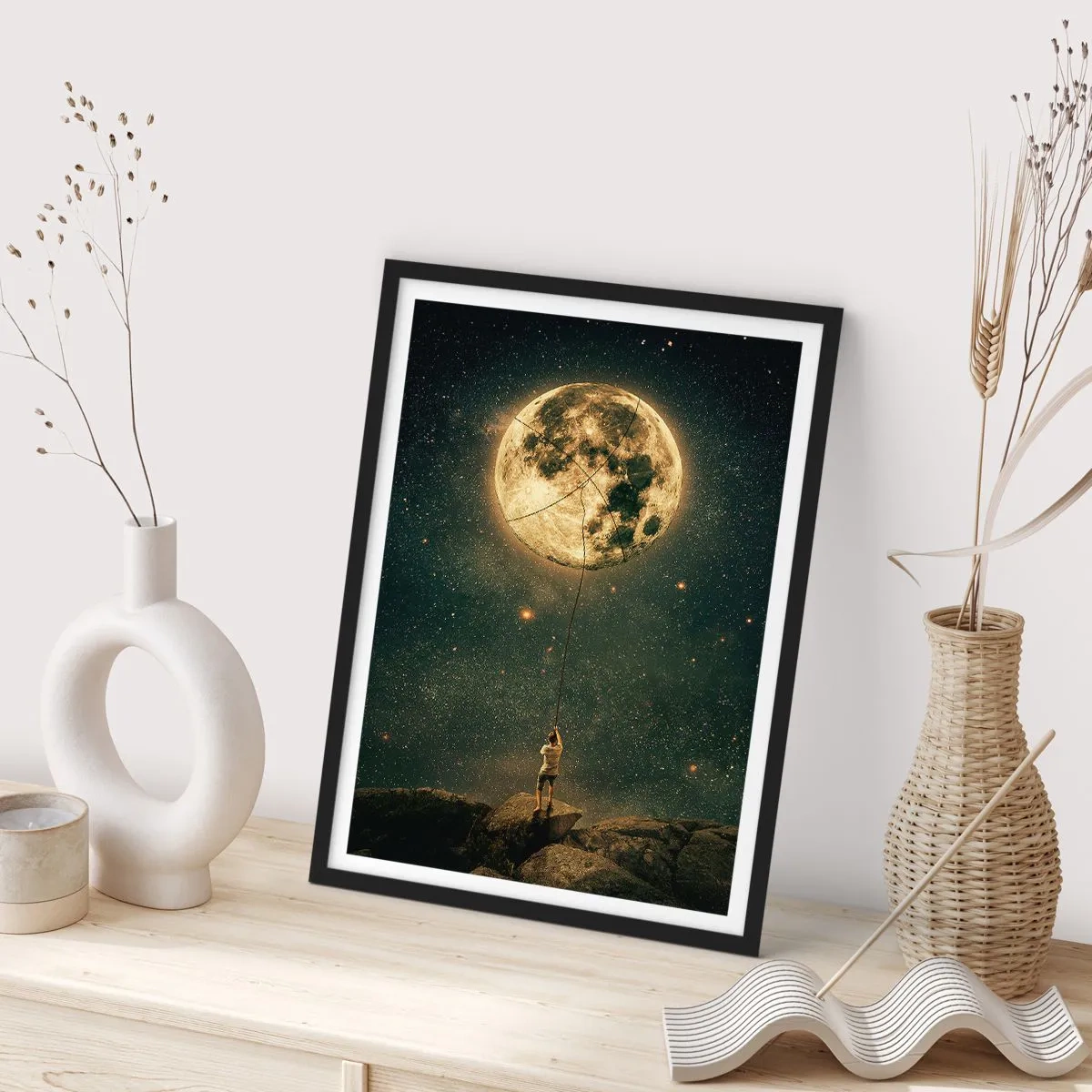 Poster in black frame - A figure holding the moon on a rope in a starry landscape. - 50x70cm - One that Stole the Moon - Modern wall decoration for the living room and bedroom ARTTOR